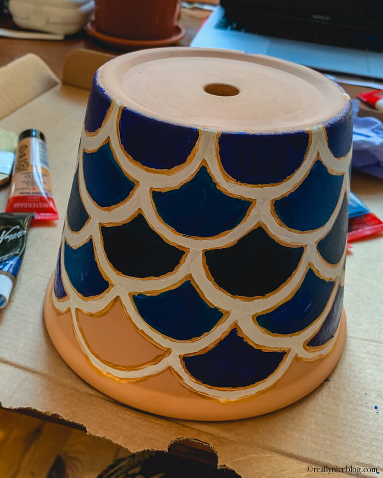 Painting terracotta pots. Using a pattern as a background